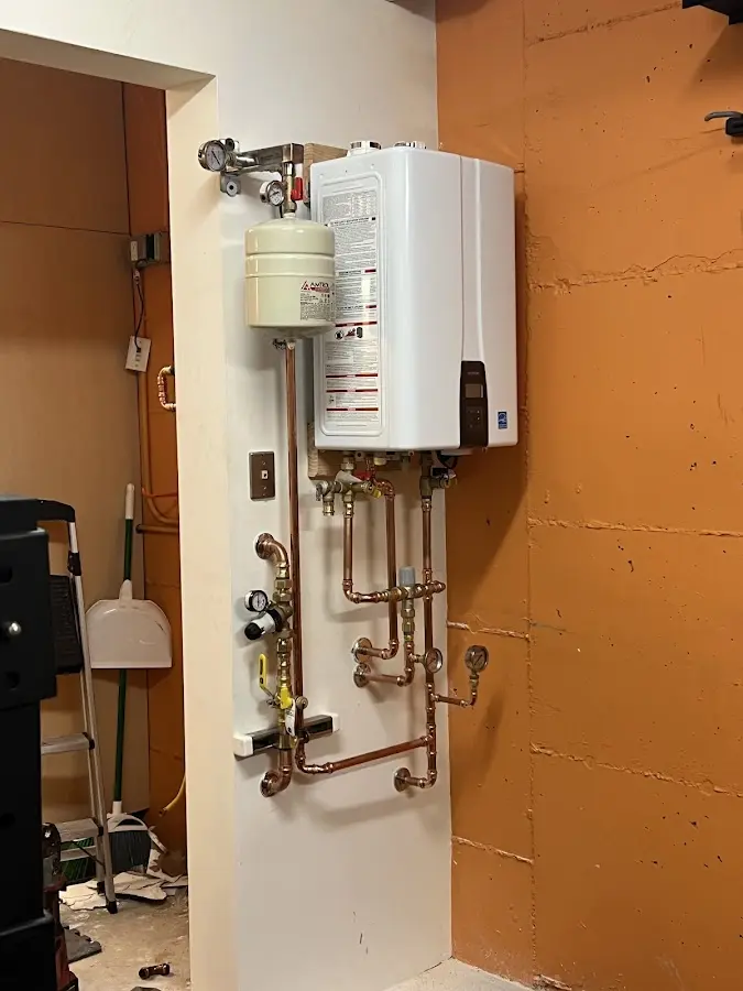 Plumbing technician inspecting water heater connections in Sleepy Hollow